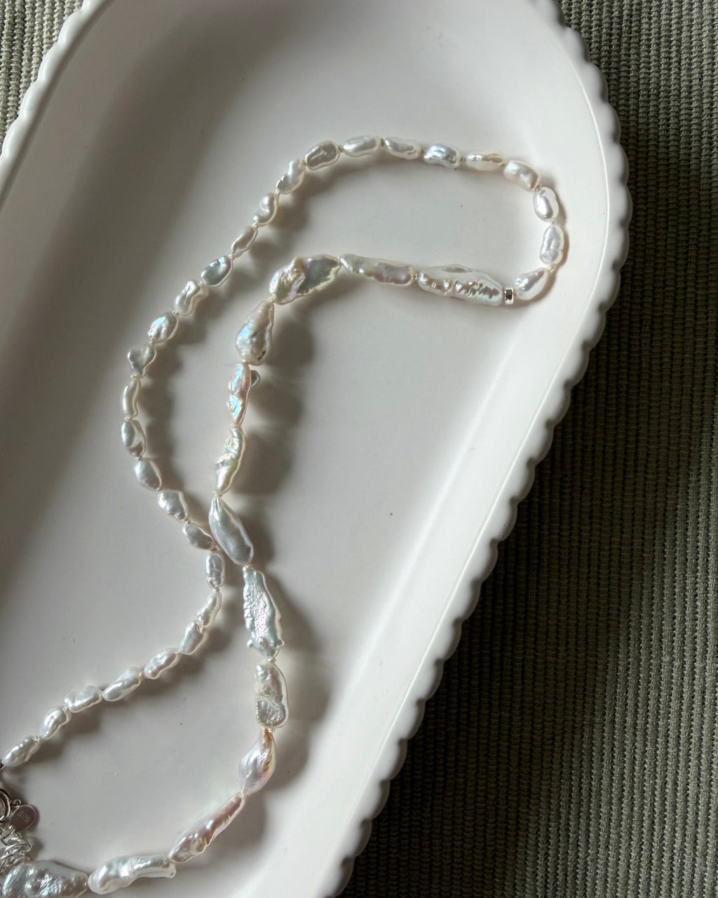 Mix of one side dainty pearls then opposite side slightly bigger pearls, strung on white silk. 