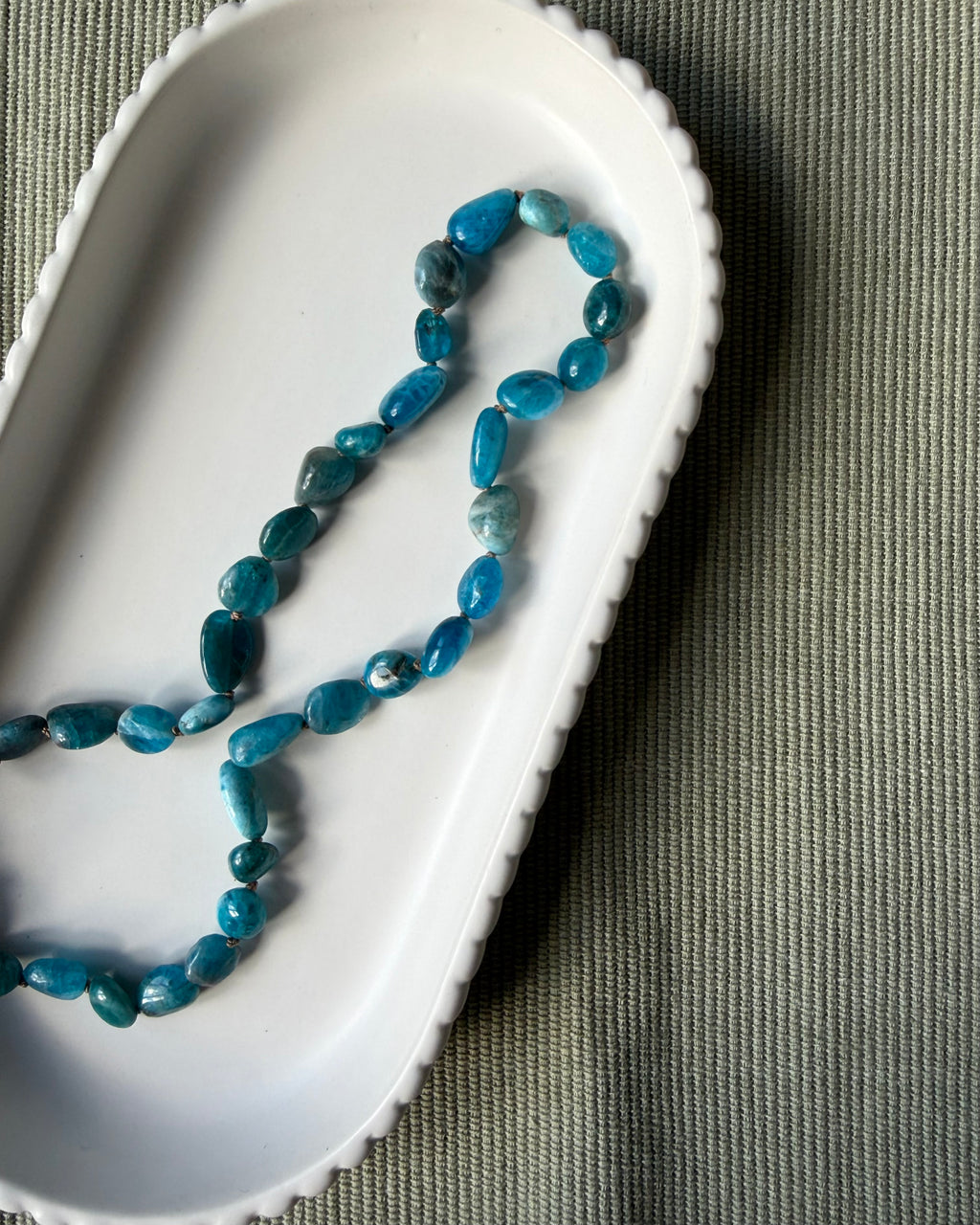 Teal-aqua apatite nugget beads knotted with beige-brown silk.