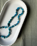 Teal-aqua apatite nugget beads knotted with beige-brown silk.