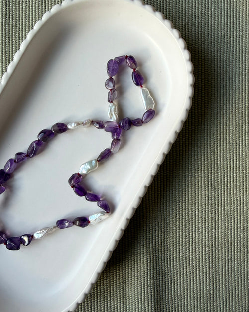 Amethyst nugget beads and long biwa pearls silk knotted and shown on a pale dish
